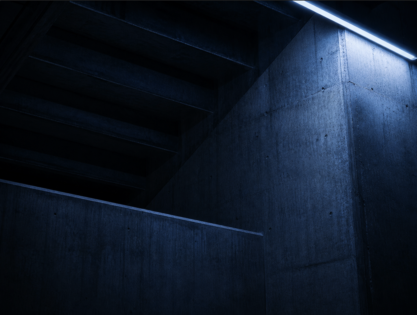 A close architectural detail of stadium concrete and a single overhead strip light.